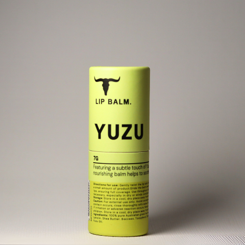 A rectangular metal tin of Bare Bones Beauty Natural Tallow Balm for tattoos, with a red-orange lid featuring a bull silhouette, partially open to reveal the balm inside.