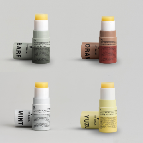 Four Tallow Lip Balm tubes from Bare Bones Beauty Australia, in BARE (green), ORANGE (orange), MINT (white), and YUZU (yellow), are arranged on a light background. Each offers natural care—get the 4-pack for $40.