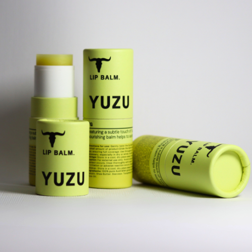 
                  
                    Three yellow Yuzu Balm tubes from Bare Bones Beauty Australia, made with grass-fed beef tallow for deep hydration, display "YUZU," "LIP BALM," and a bull logo; two stand upright (one open), one lies on its side on a plain white background.
                  
                