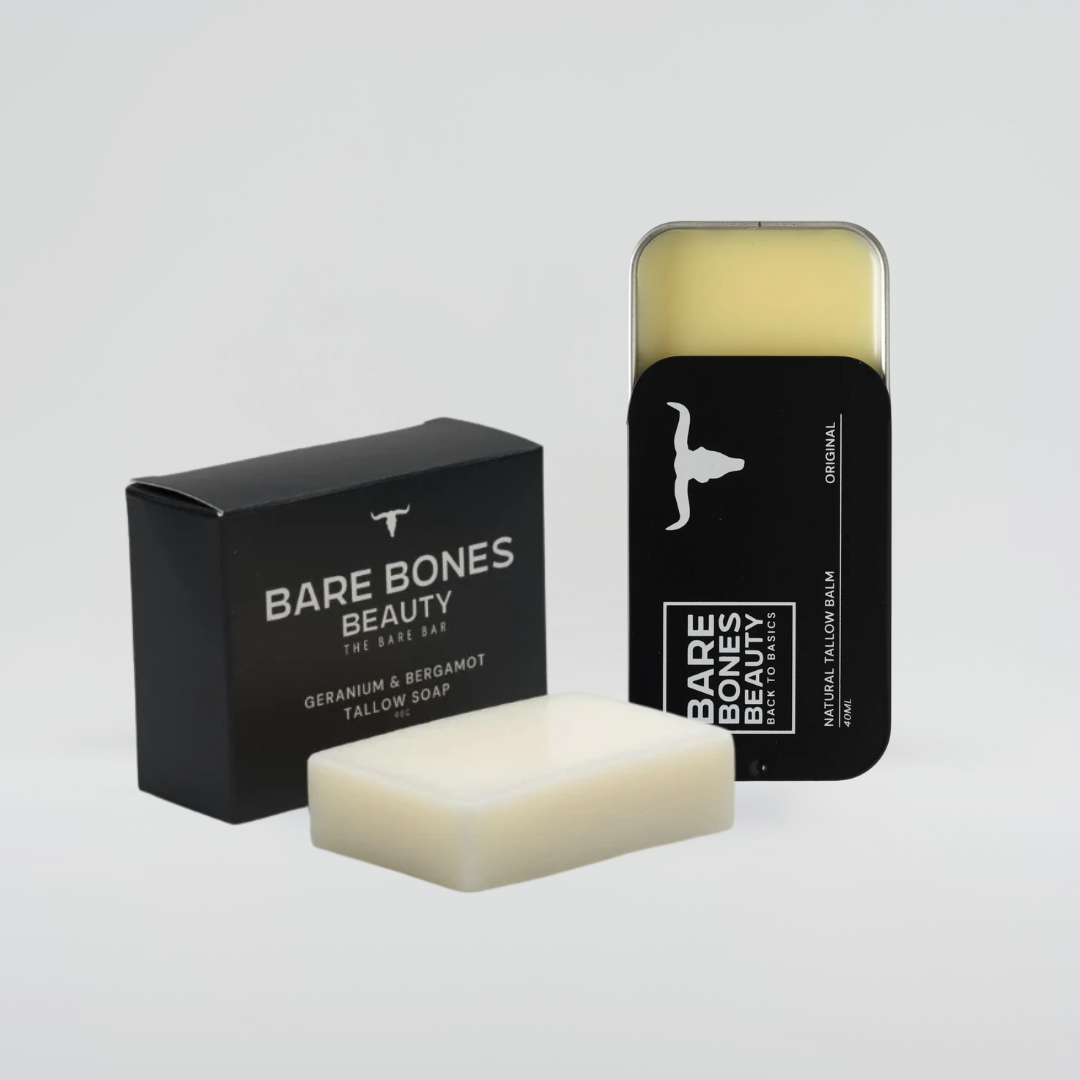 The Soap & Balm Bundle by Bare Bones Beauty Australia features a black box, a white tallow soap bar, a metal tin balm, and an exfoliating bag—all with minimalist black and white packaging for a spa-like touch.